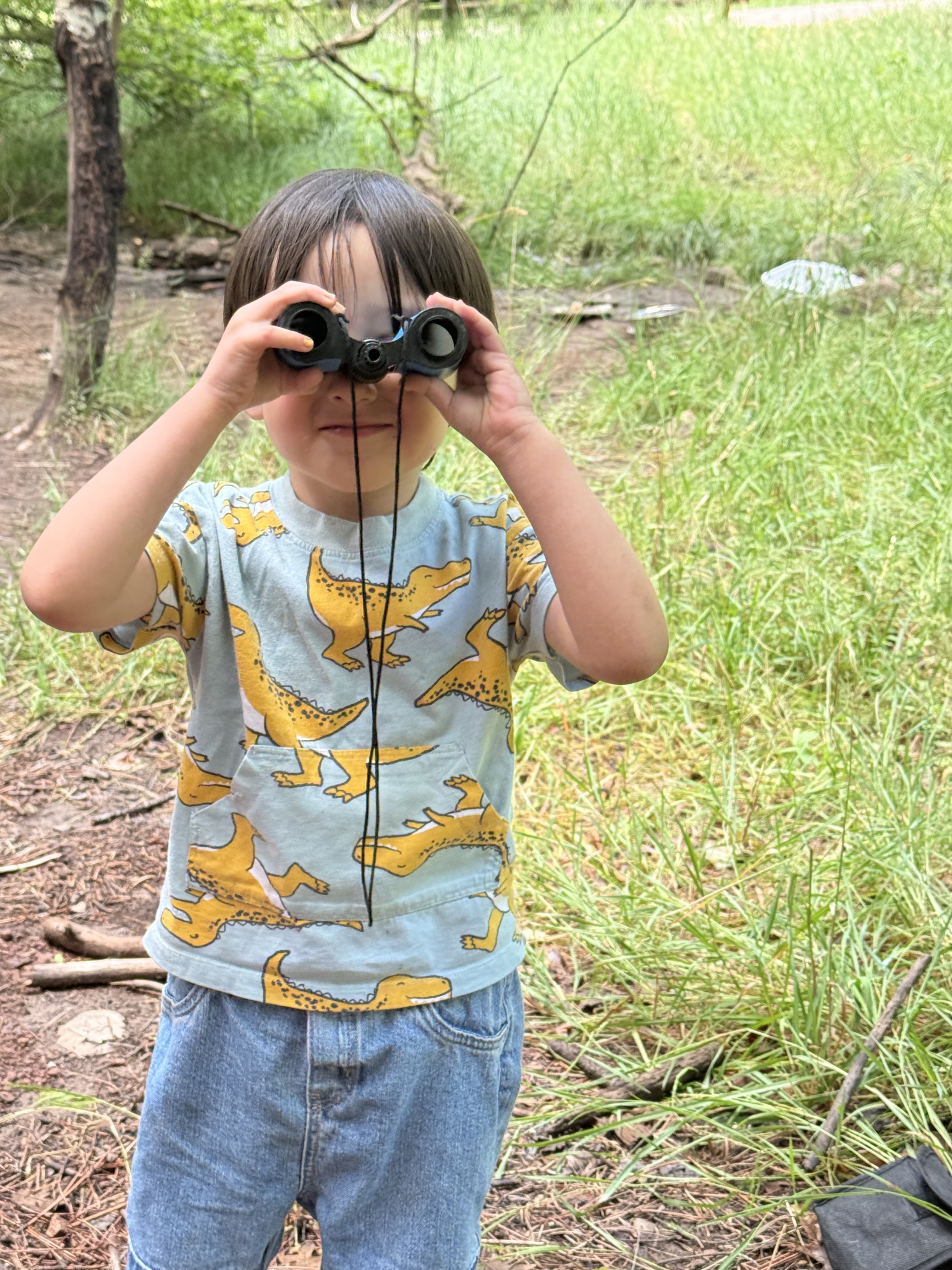 child looking through upside down binoculars
